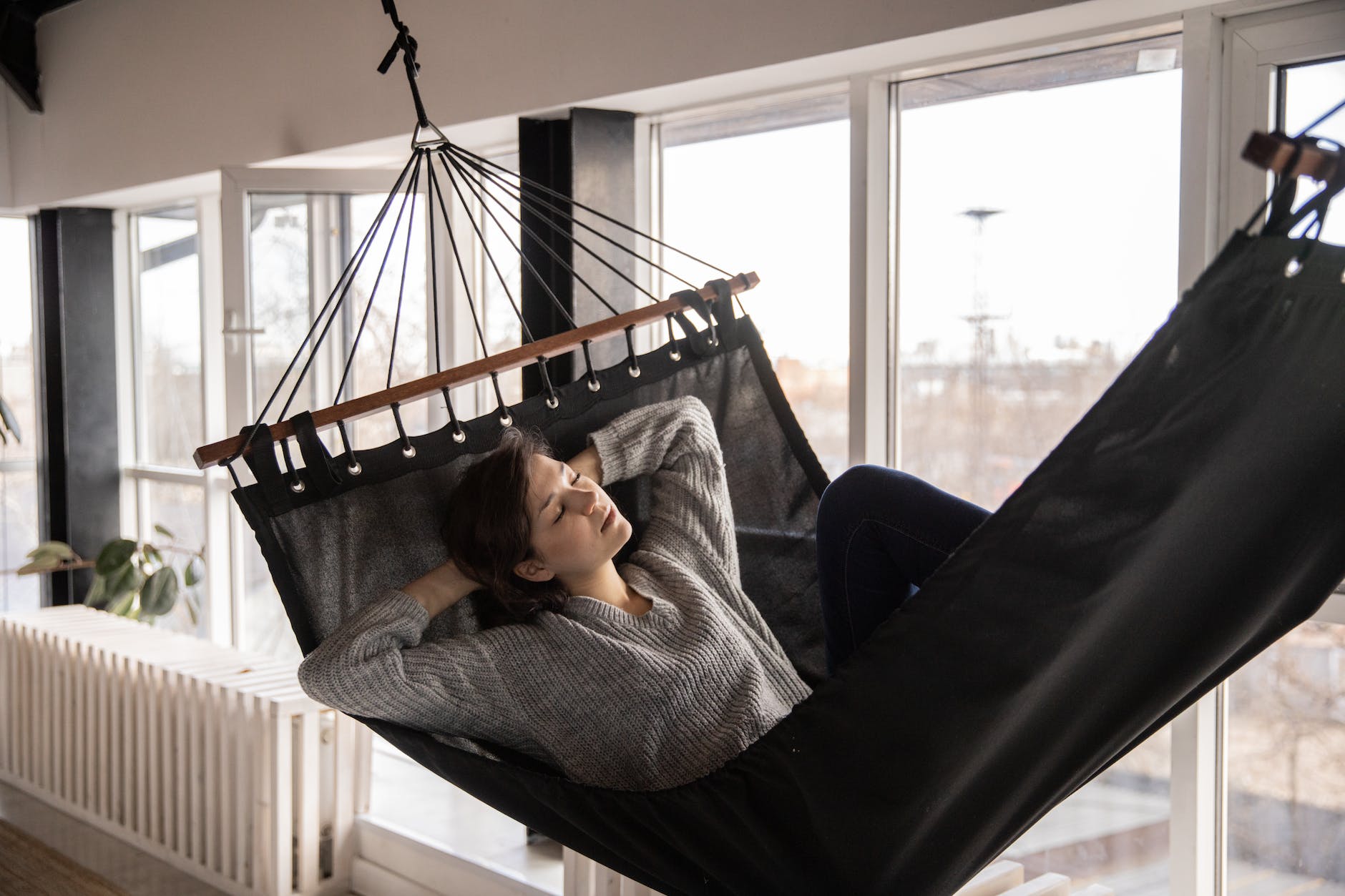 tired woman sleeping in cozy hammock in flat